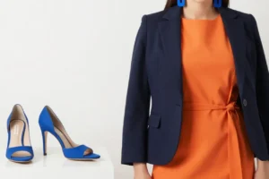 A woman styling an orange dress with a navy blue blazer, blue heels, and statement earrings. This colour combination for orange dress creates a striking contrast, combining the vibrancy of orange with the sophistication of navy blue. Get more ideas at yesvsno.net