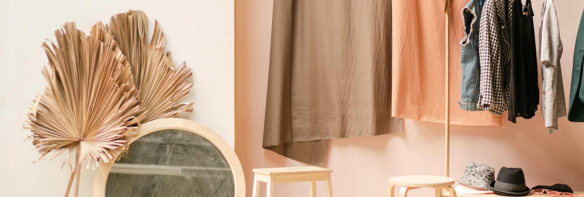 A stylish, minimalist wardrobe setup with clothing hanging neatly on a rack and accessories arranged beside it. Perfect for organizing a versatile capsule wardrobe. Find more ideas at yesvsno.net.