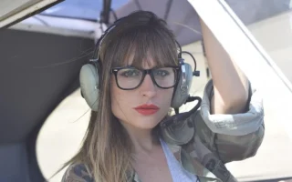 Woman with aviator-style eyeglasses, perfect for aviation enthusiasts, showcasing Perfect Eyeglasses on yesvsno.net.