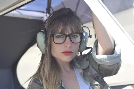 Woman with aviator-style eyeglasses, perfect for aviation enthusiasts, showcasing Perfect Eyeglasses on yesvsno.net.