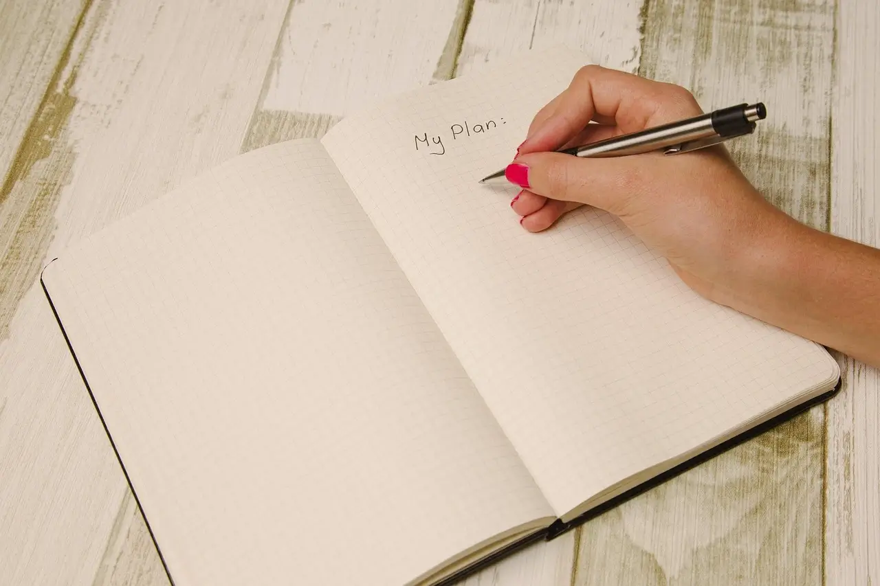 Hand writing in a notebook with the title 'My Plan' to organize the upcoming week as part of a productive Sunday routine – YesvsNo.net.