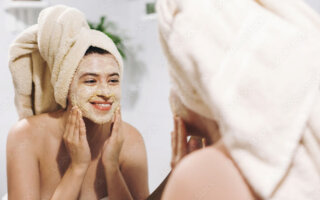 women-applying-face-mask-checking-in-mirror