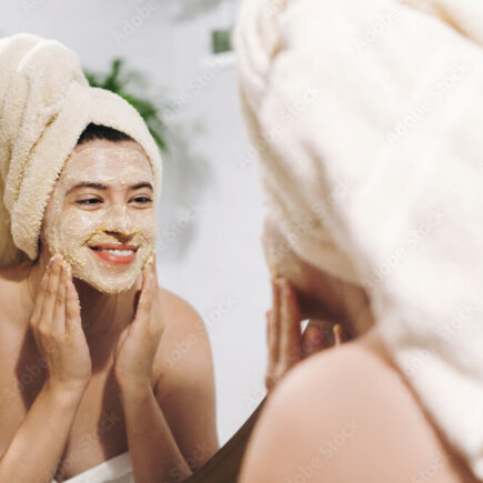 women-applying-face-mask-checking-in-mirror