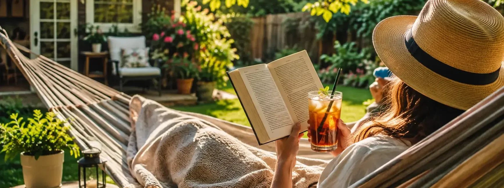 A person relaxing in a hammock or lounge chair in their own backyard with a book and iced drink, warm sunny afternoon, cozy and content mood.yes or no to taking a staycation this summer featured image.