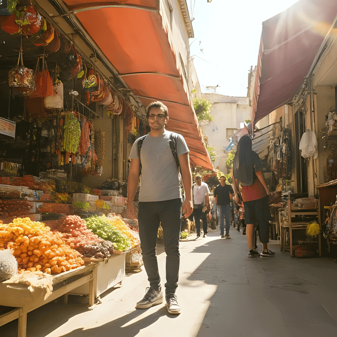 Man-walking-through-a-sunlit-market-street-filled-with-vibrant-fruits-and-vegetables-in-an-outdoor-setting