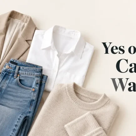 A clean flat-lay of a small, coordinated set of neutral-toned clothing pieces, like a blazer, jeans, a white shirt, and a sweater, arranged on a light surface, soft natural light, bright and modern