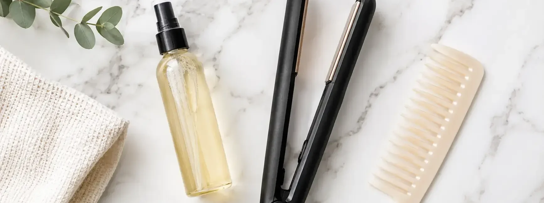 A flat lay of a heat protectant spray bottle, a flat iron, and a wide-tooth comb on a clean white marble surface. Soft natural lighting, minimal editorial style. No text overlays.yes or no to heat protectant every time.