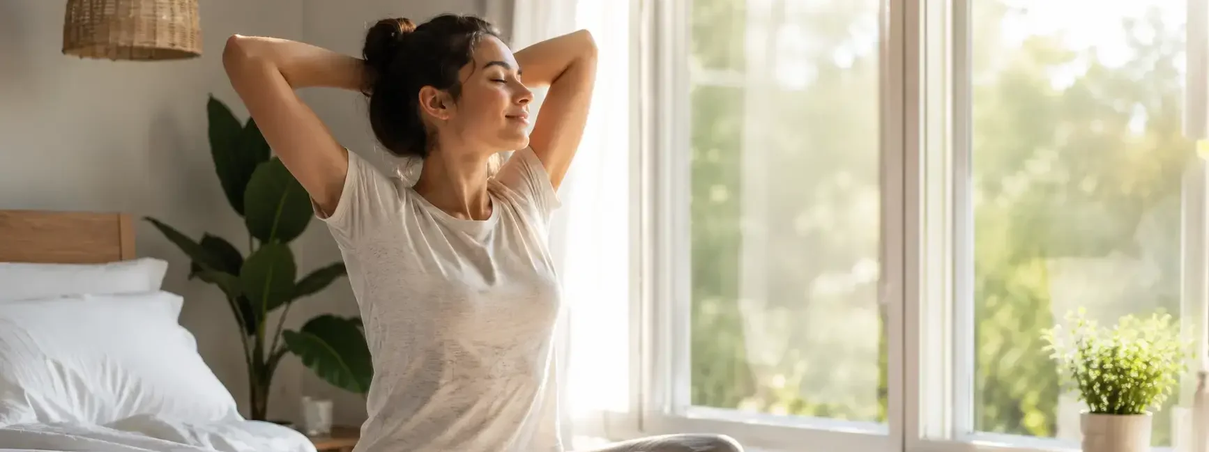 A person calmly stretching by a bright window in the early morning, a cup of water or coffee nearby, soft natural light, uncluttered bedroom setting-yes or no to morning routines featured image.